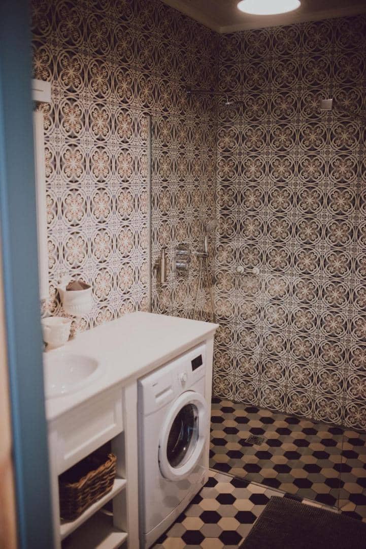 Apartaments ar skatu uz parku — vannas istaba ar rakstainām flīzēm un veļas mašīnu